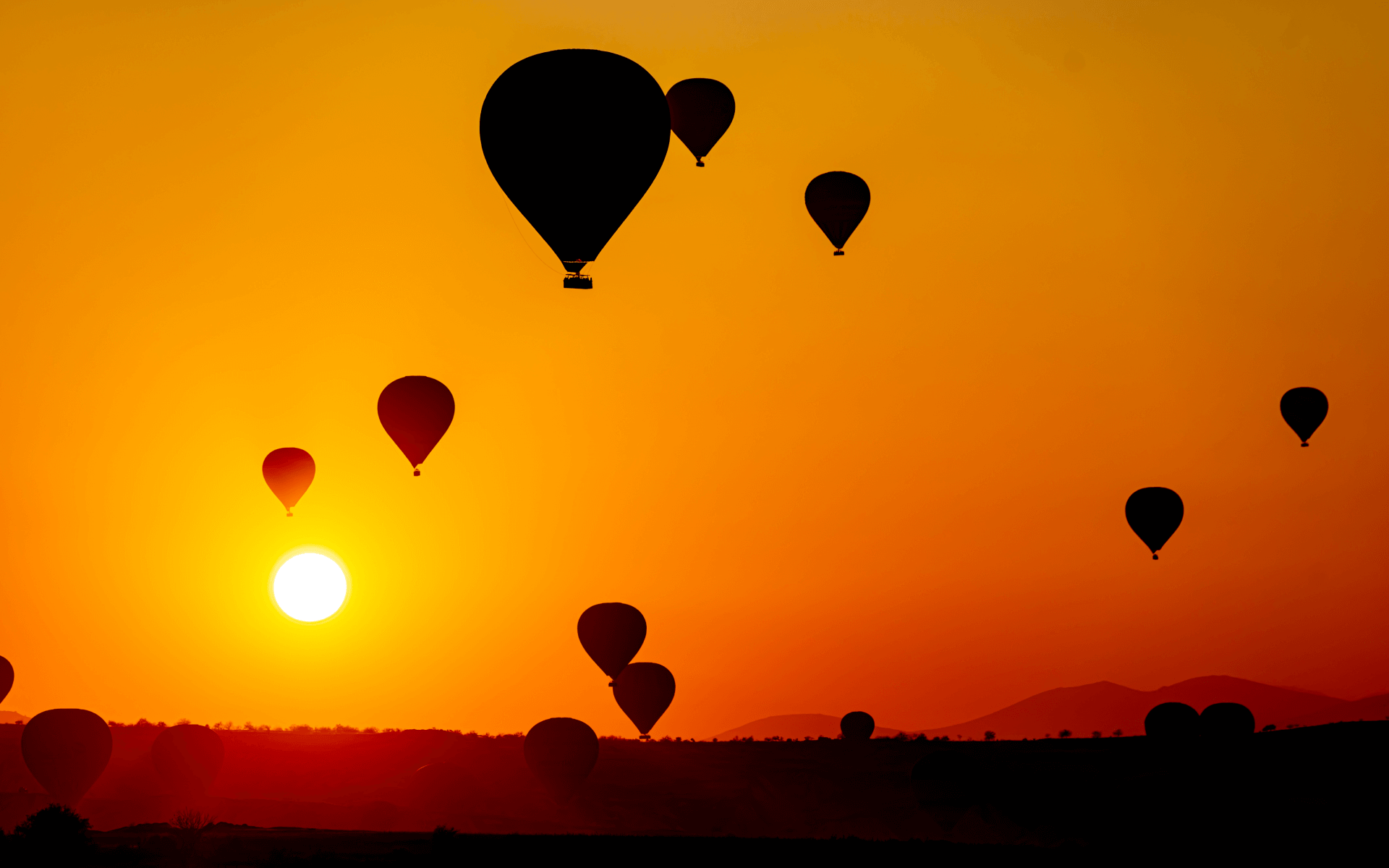 Hot air balloons drifting above fairy chimneys in Love Valley Cappadocia
